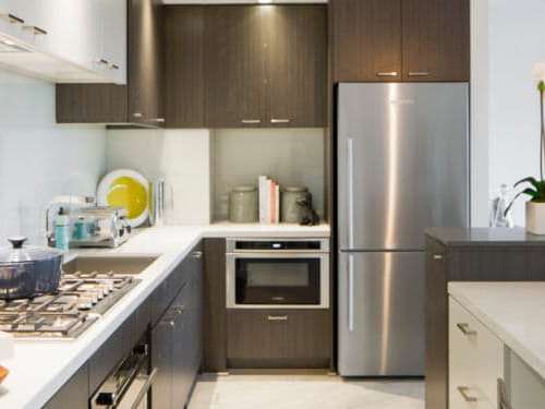 Designed for both beauty and function, the kitchen shows off sleek, stylish efficiency while concealing essential utility and features.