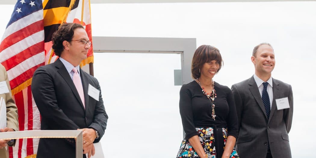 Three Bozzuto leaders & representatives standing on stage for the Development Company of the Year award.