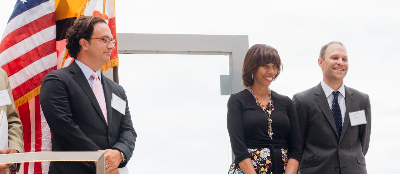 Three Bozzuto leaders & representatives standing on stage for the Development Company of the Year award.