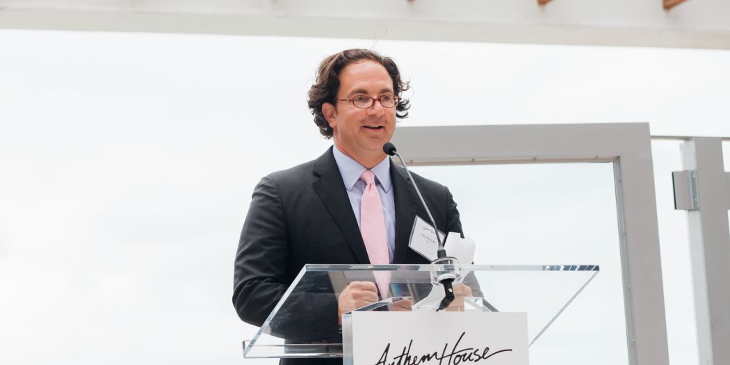 Toby Bozzuto, president and CEO of the Bozzuto Group, speaking on a podium.