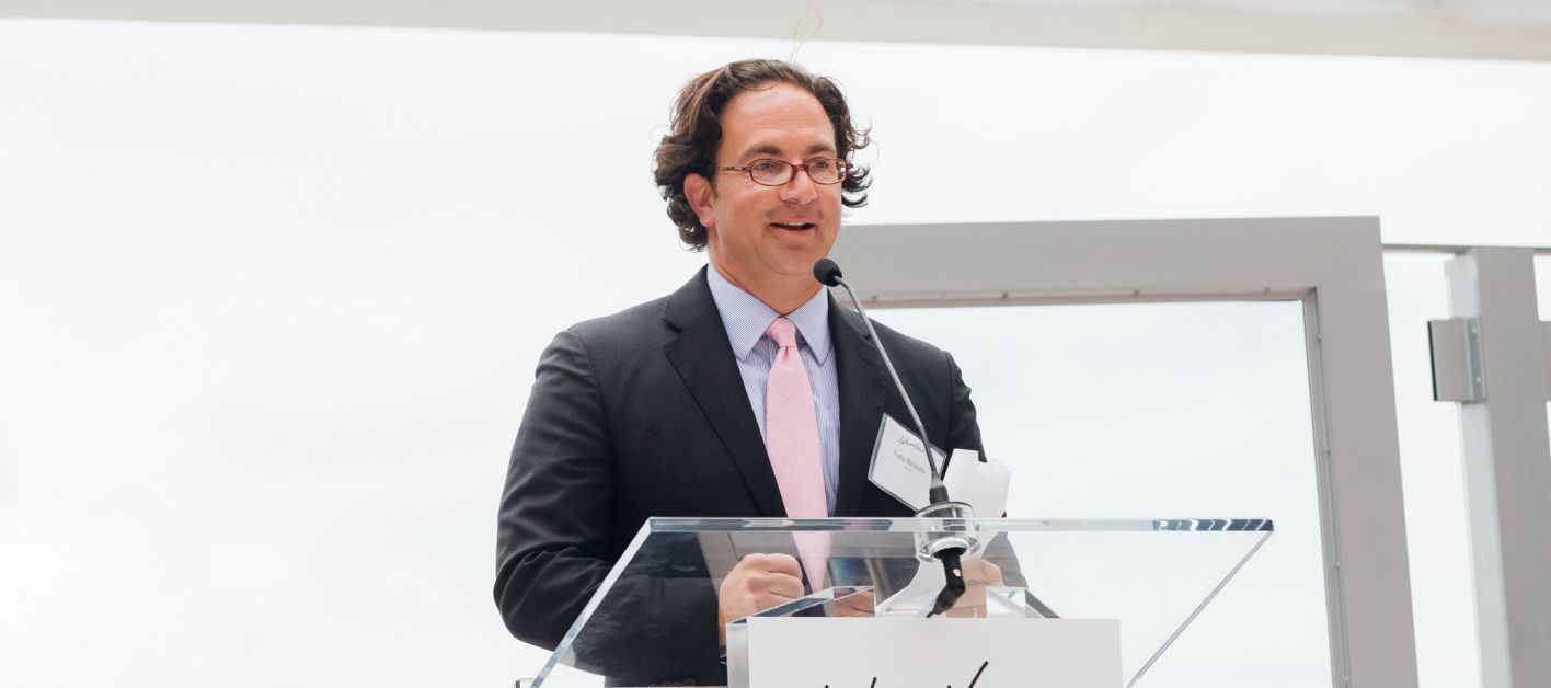 Toby Bozzuto, president and CEO of the Bozzuto Group, speaking on a podium.