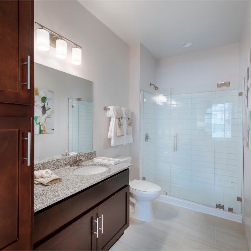 Some spaces offer a convenient glass shower and linen cabinet.