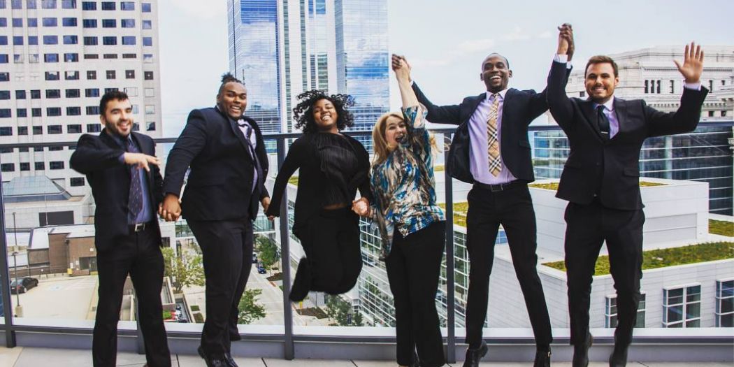 Happy Bozzuto colleagues celebrating success by jumping together.