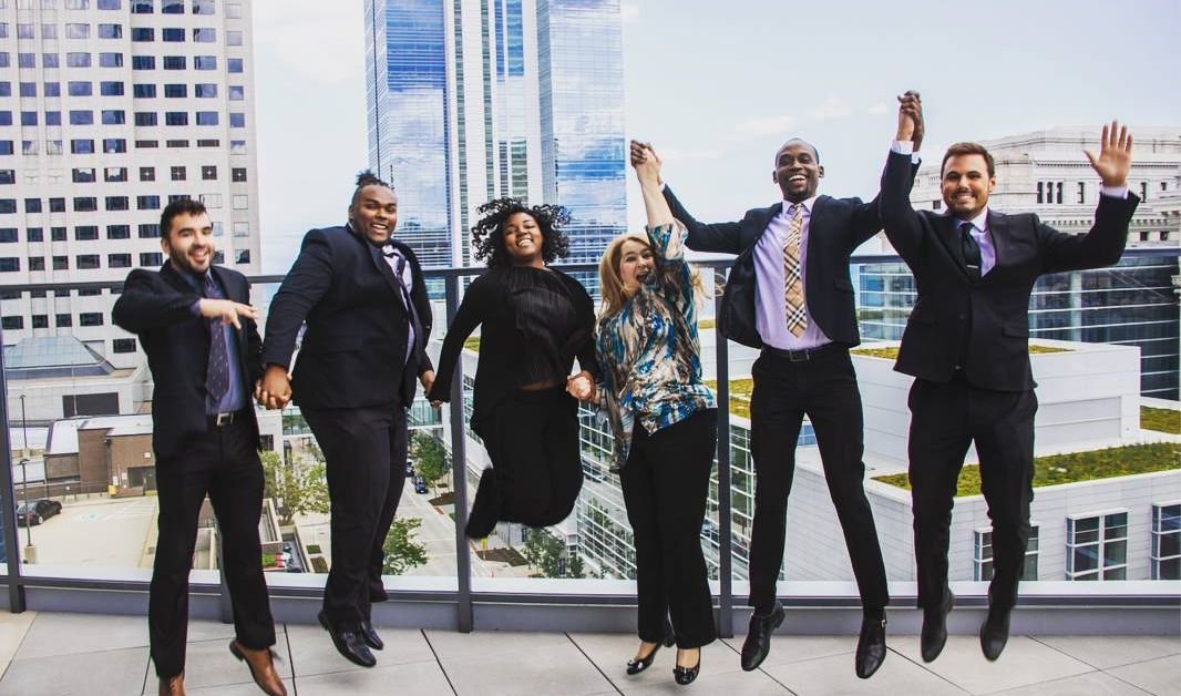 Happy Bozzuto colleagues celebrating success by jumping together.