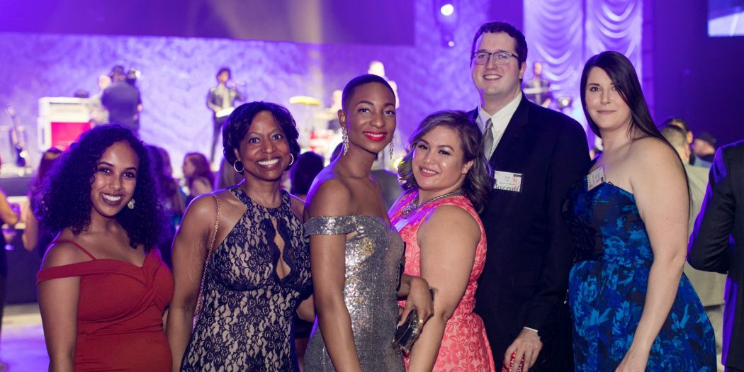 A cheerful group of people smiling and posing for a photo at a Bozzuto party.