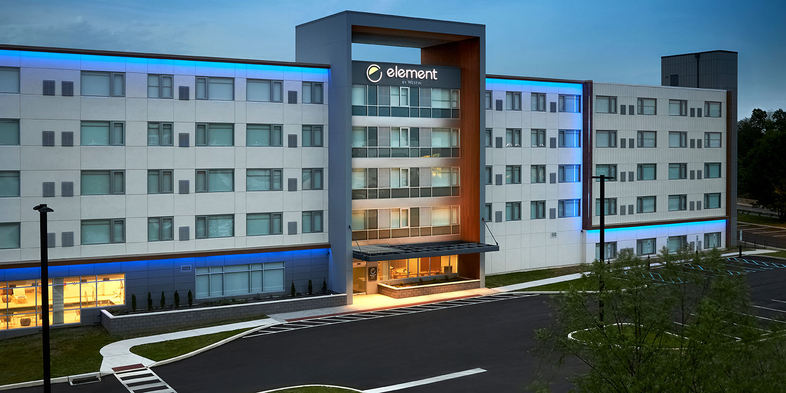 Building front of Element by Westin at dusk with exterior blue lights illuminating the building