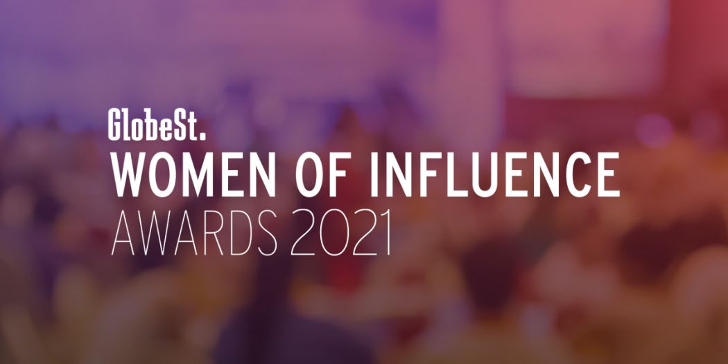 GlobeSt. Women of Influence Awards signage in a purple, blurred backdrop.