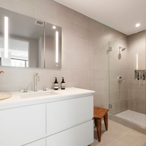 Porcelanosa® tile, Robern® medicine cabinets, and Kohler® fixtures in bathrooms