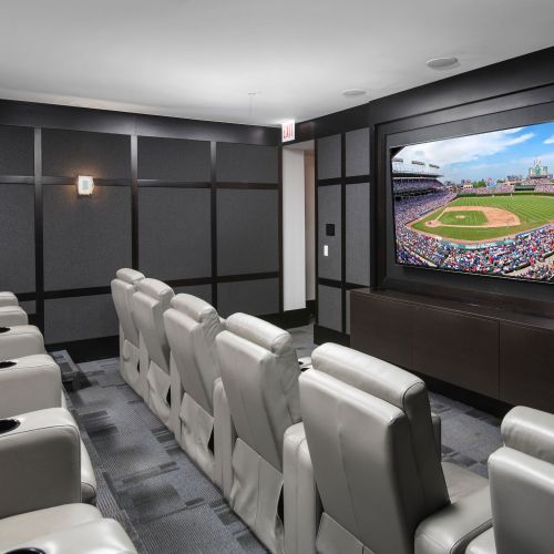 State-of-the-art movie theater with oversized screen and stadium-style leather seating.