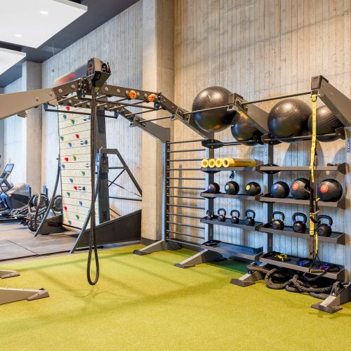 Modern exercise equipment and turf area for full-body strength training.