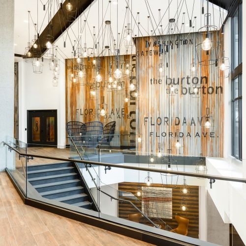 Industrial upper lobby with luminous, dripping light fixtures. 