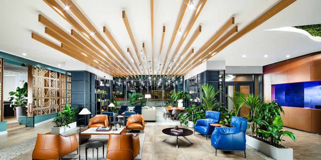 Grand lobby of a Bozzuto apartment featuring a stunning wooden ceiling and luxurious furnishings.