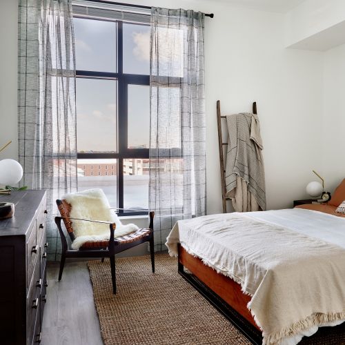 Full length windows creating an airy bedroom space.