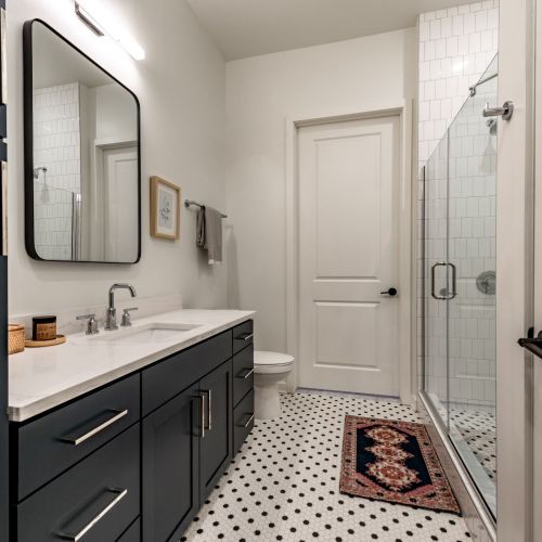 Spa-inspired baths with tile flooring and modern metal framed mirrors