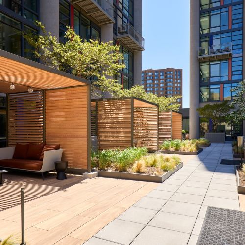 Private cabana lounges adjacent to grilling stations and lush landscaping