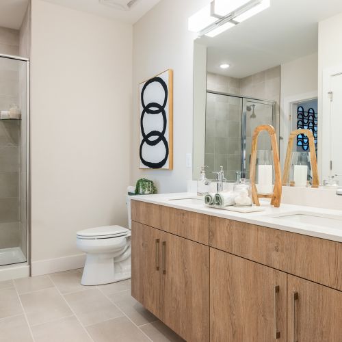 Elegant bathrooms with quartz vanity tops and modern 12 x 24 tile flooring
