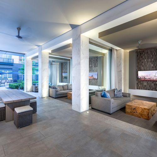 Open-air loggia with large screen TVs and cozy seating areas