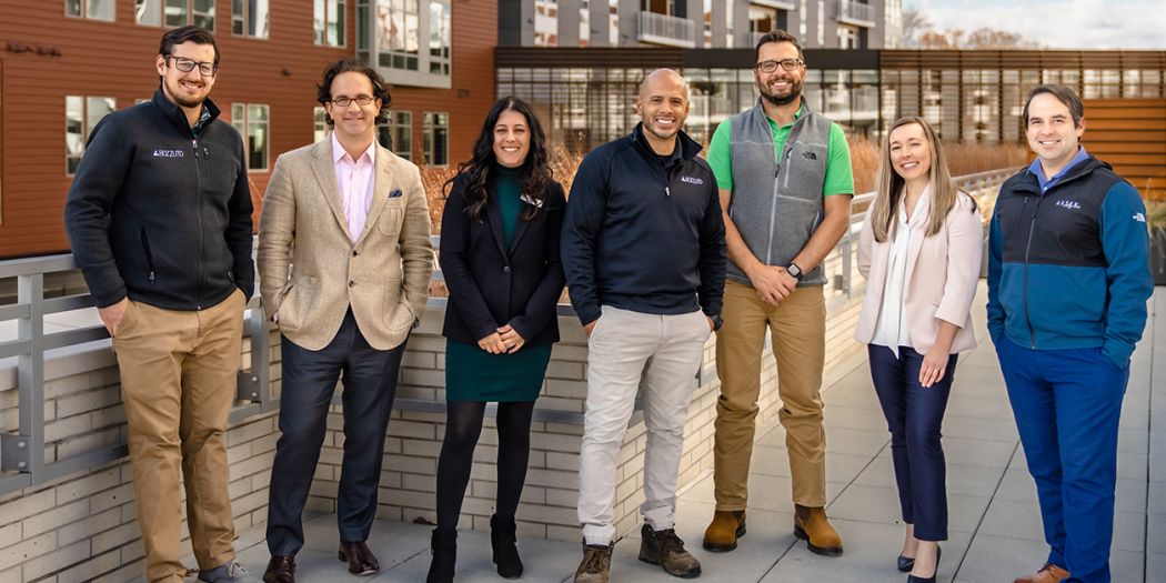 Toby Bozzuto & fellow Bozzuto professionals posing on a ramp of an office building.