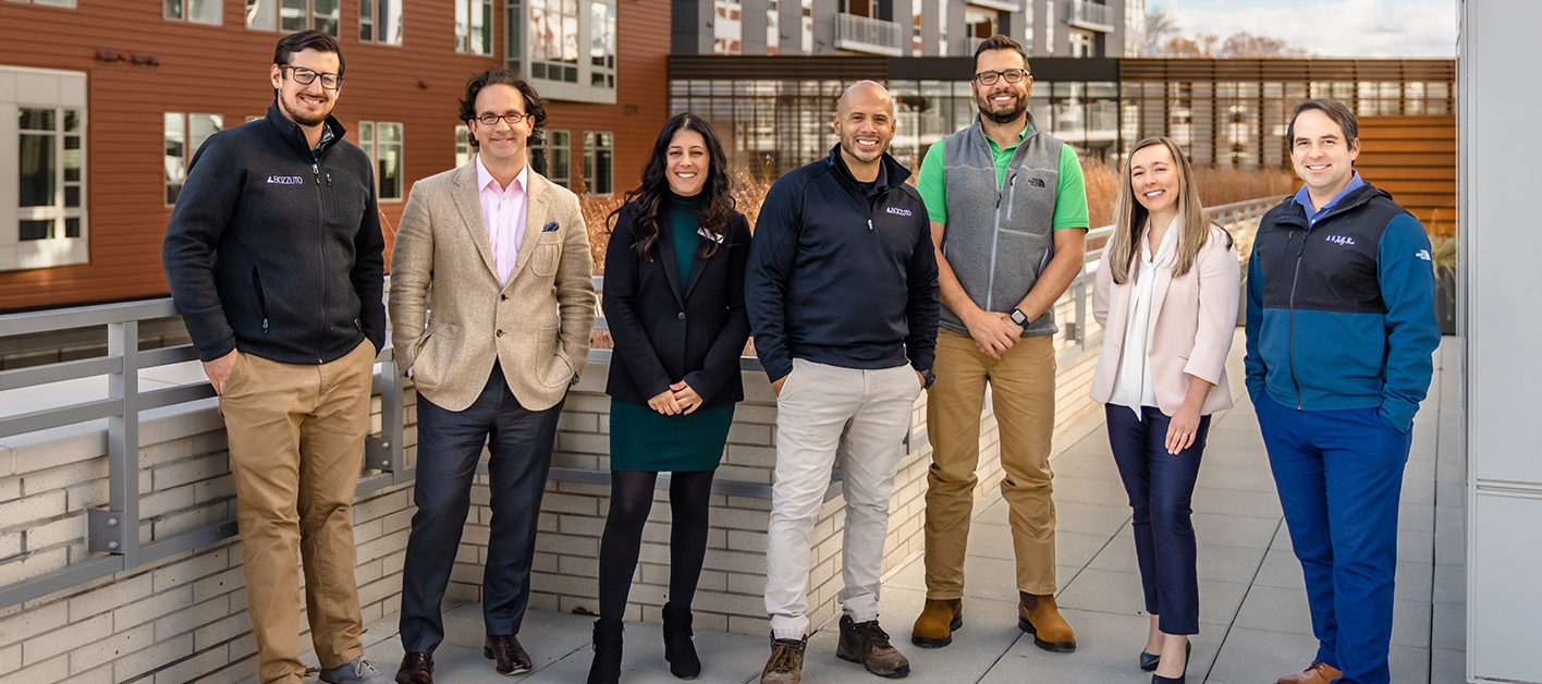 Toby Bozzuto & fellow Bozzuto professionals posing on a ramp of an office building.
