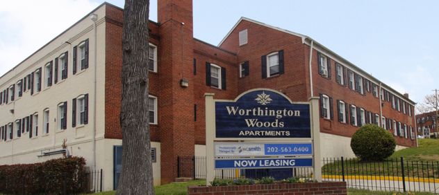 Worthington Woods luxury apartment in Washington, DC, exterior street-corner view with a "Now Leasing" signage.