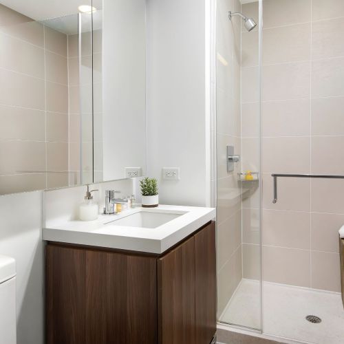 Spa-inspired bathrooms boast frameless shower doors and and ample storage. 