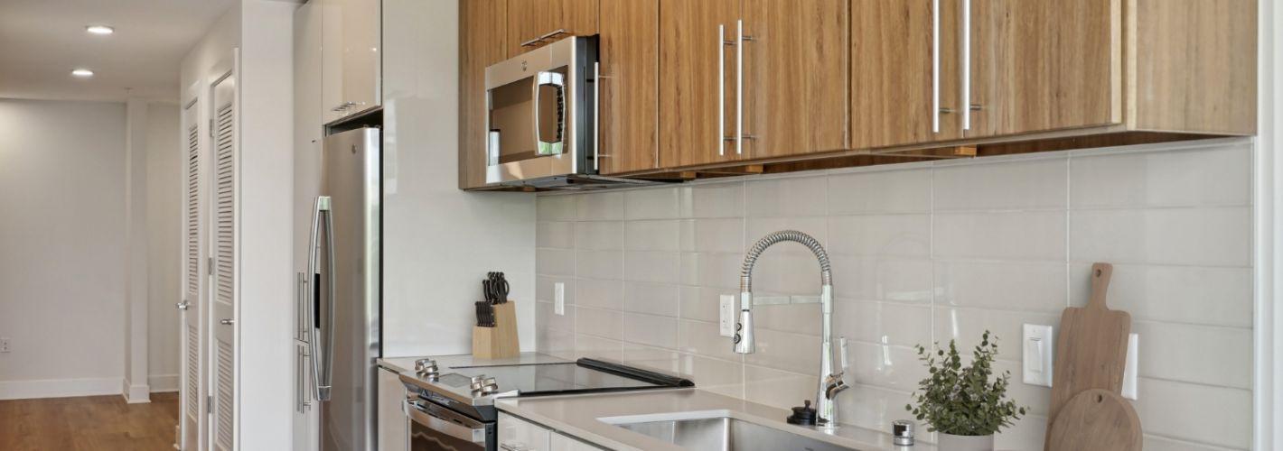 Three Collective : Stainless steel appliances, quartz countertops, and subway tile backsplashes