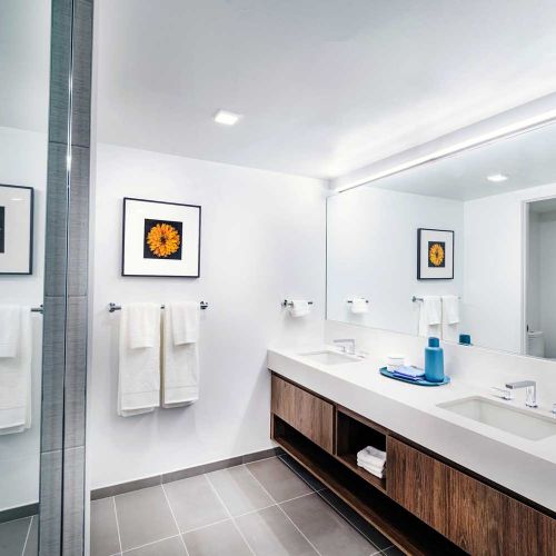 Hotel-inspired bathrooms featuring backlit mirrors
