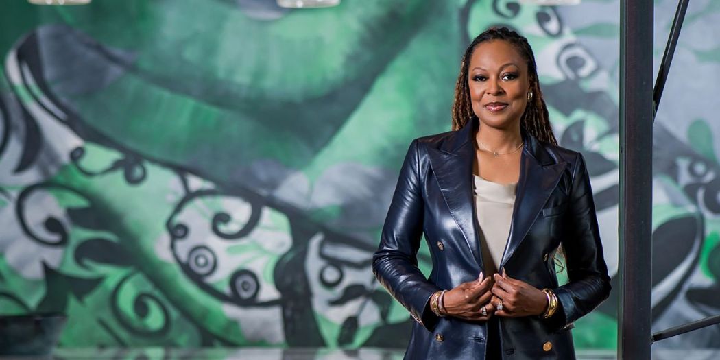 Stephanie Williams, Bozzuto Management Co. President, posing in front of a mural.