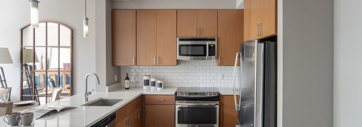 Cathedral Commons : Refined kitchens featuring white quartz countertops and stainless steel appliances