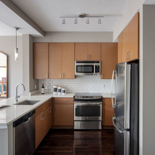 Cathedral Commons : Refined kitchens featuring white quartz countertops and stainless steel appliances