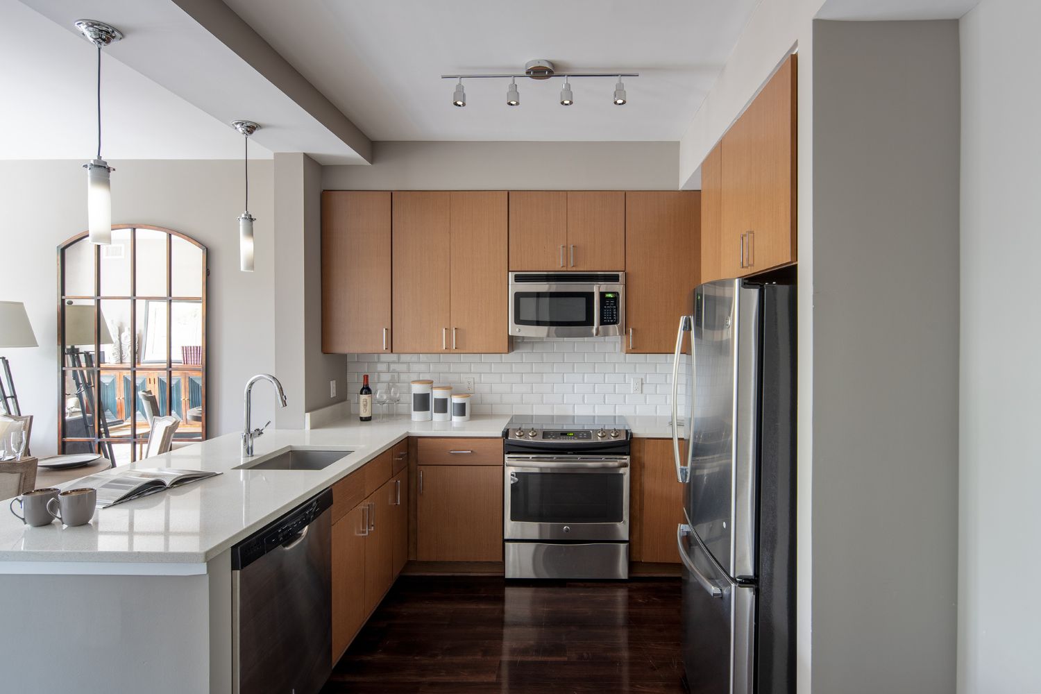 Cathedral Commons : Refined kitchens featuring white quartz countertops and stainless steel appliances