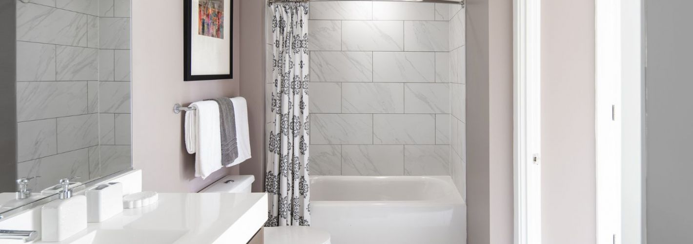 Cathedral Commons : Sleek bathrooms featuring linen tiling and Carrara marble vanities