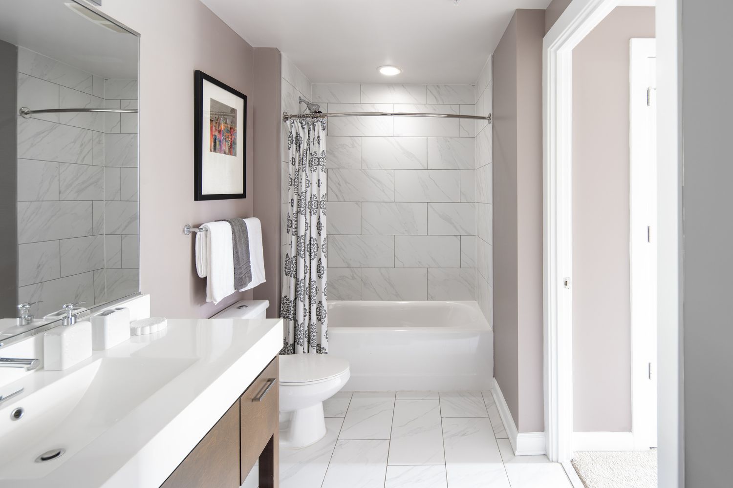 Cathedral Commons : Sleek bathrooms featuring linen tiling and Carrara marble vanities