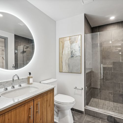 Spacious vanities with hotel-style, backlit mirrors in bathrooms