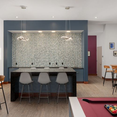 Pubroom with kitchen, pool table, booth seatings, and bar tables