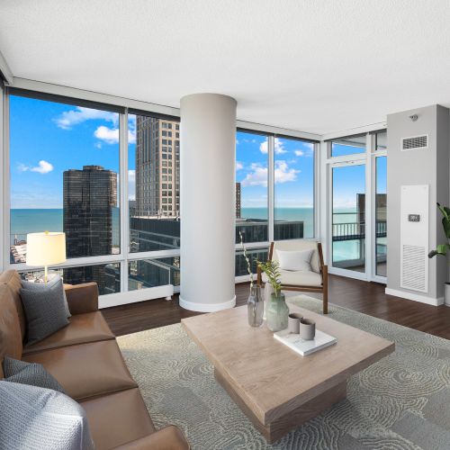 Living and kitchen area with a blue velvet couch, media console, and large decorative artwork.
