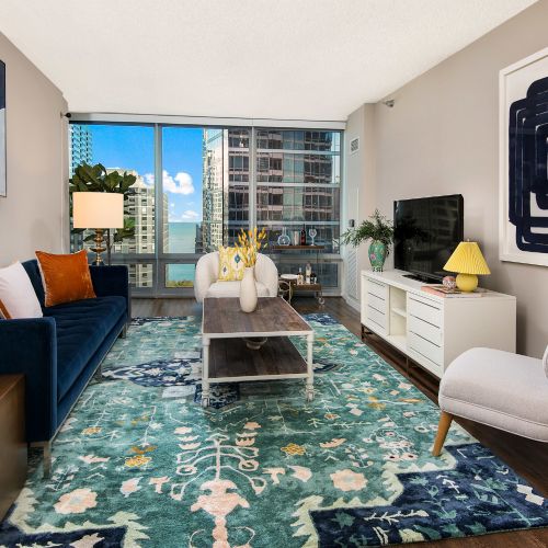 Decorated living area featuring wood flooring and tall windows.