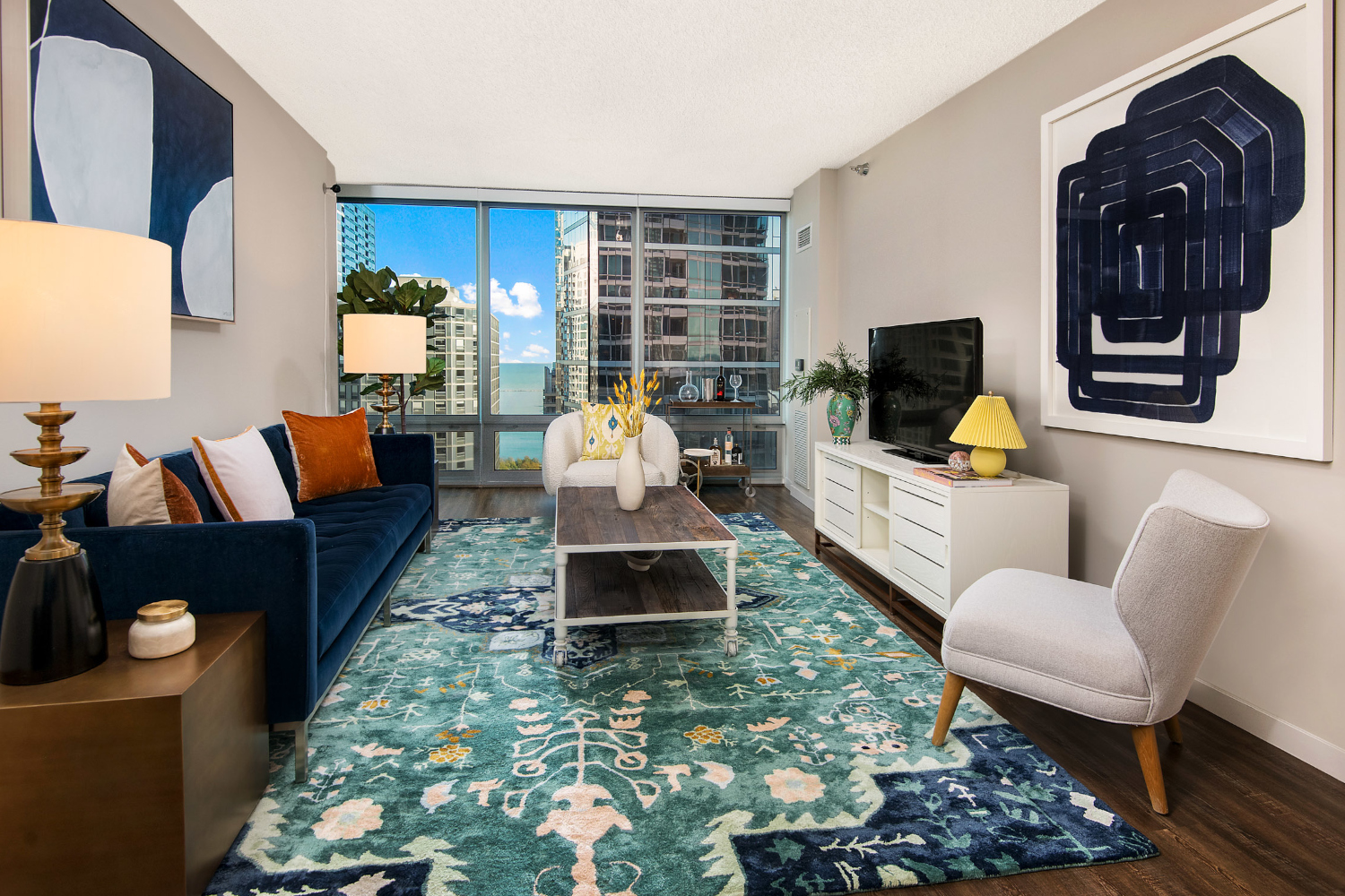 Decorated living area featuring wood flooring and tall windows.