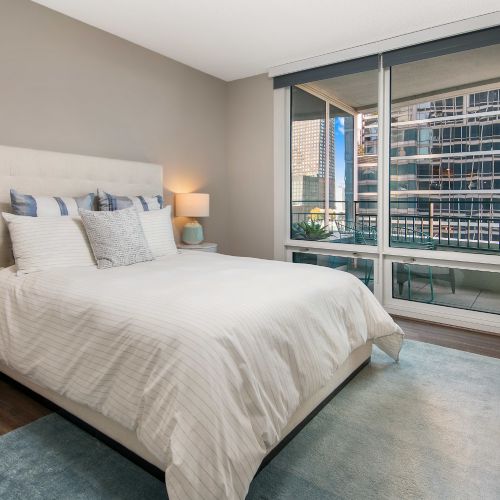 Wide angle of a decorated bedroom with a blue gray accent wall.