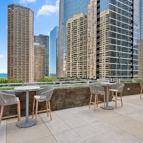 Atwater's outdoor sundeck with two-person patio seating overlooking Chicago's cityscape and Lake Michigan.