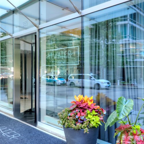 Close up of Atwater's glass façade and front entrance with tall planters positioned by the door.