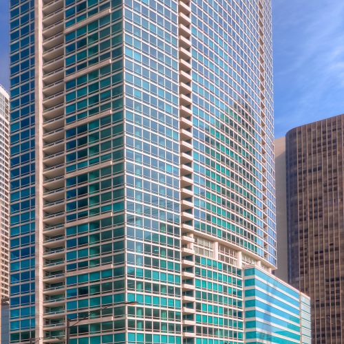 Low angle of the Atwater building with a sun flare reflecting off the glass façade.