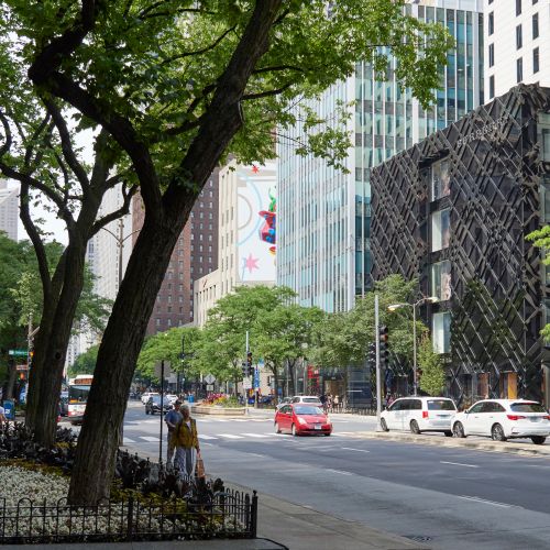 Eye-level street view of pedestrians walking the Magnificent Mile surrounded by stores including Cartier and Burberry.