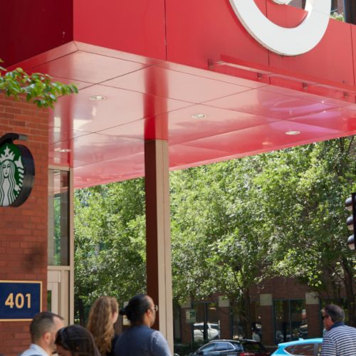 Exterior view of Target and Starbucks with pedestrians.