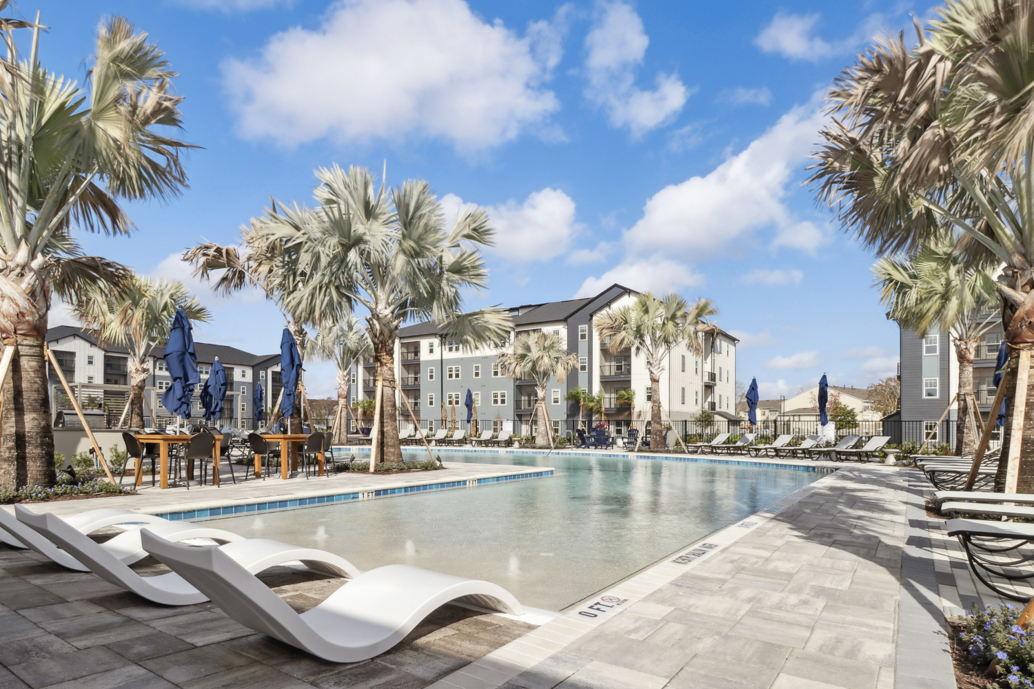 Avida : Avida's resort-style pool features an abundance of comfortable seating. 	