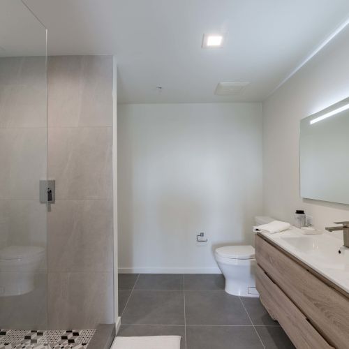 Bathrooms with frameless glass stand-up showers and expansive vanity space