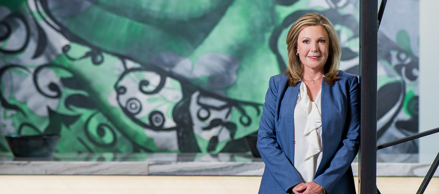 Julie Smith, Chief Administrative Officer of Bozzuto, standing in front of a mural.