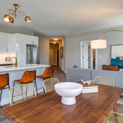 Open-concept kitchen and living room with gray cabinets and bar seating