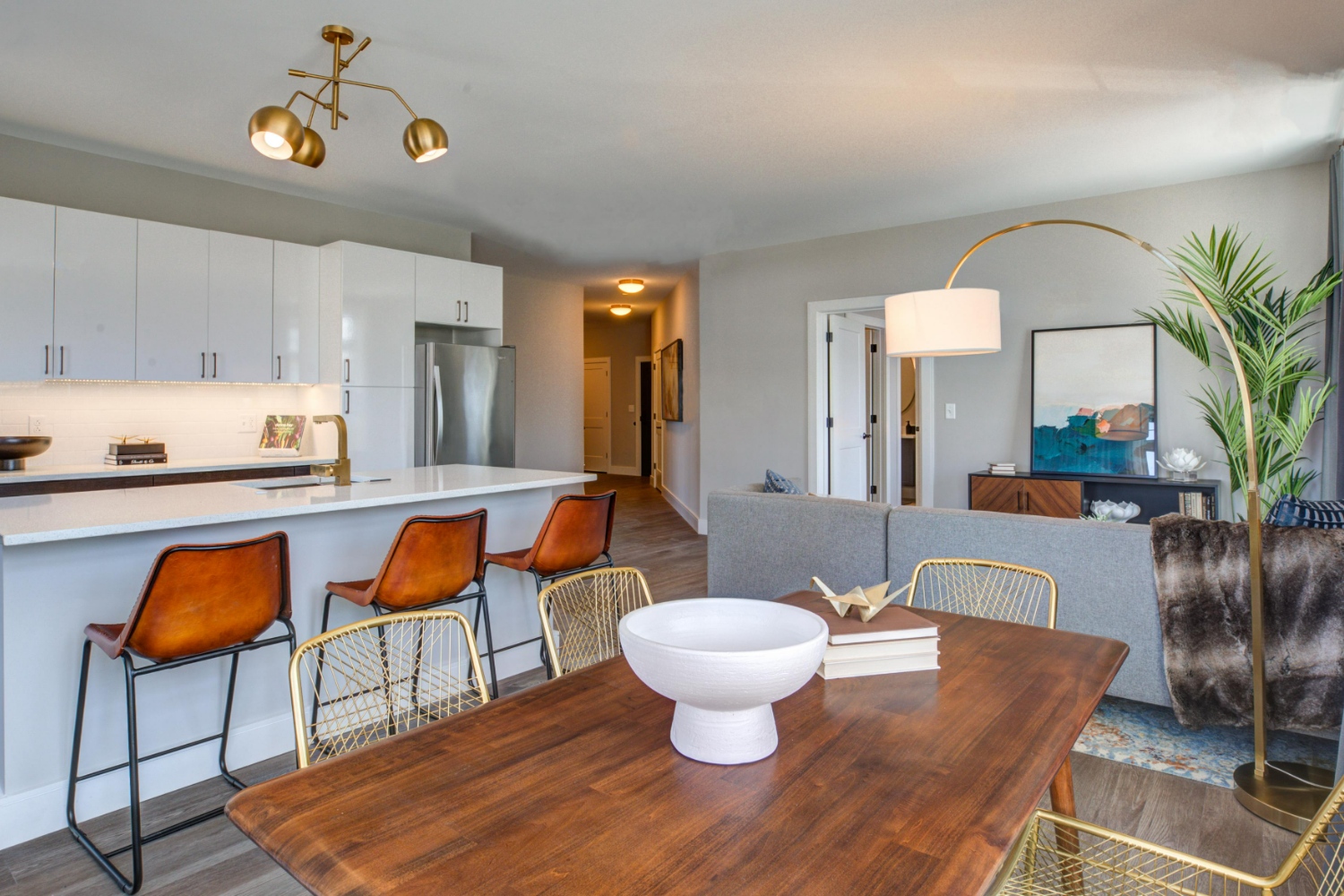 Open-concept kitchen and living room with gray cabinets and bar seating