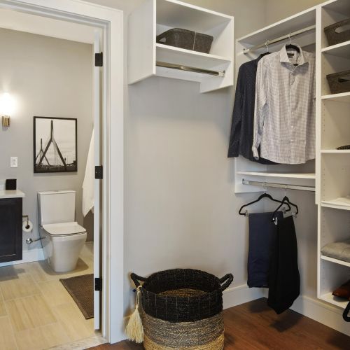Closet and bathroom space showcasing closet location within the primary bathroom and built-in organization system within closet space